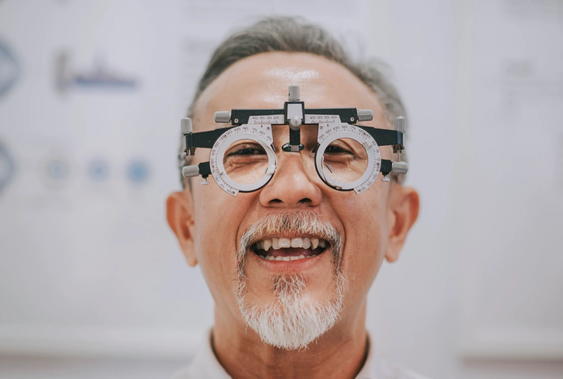 Smiling man wearing optometry testing glasses.