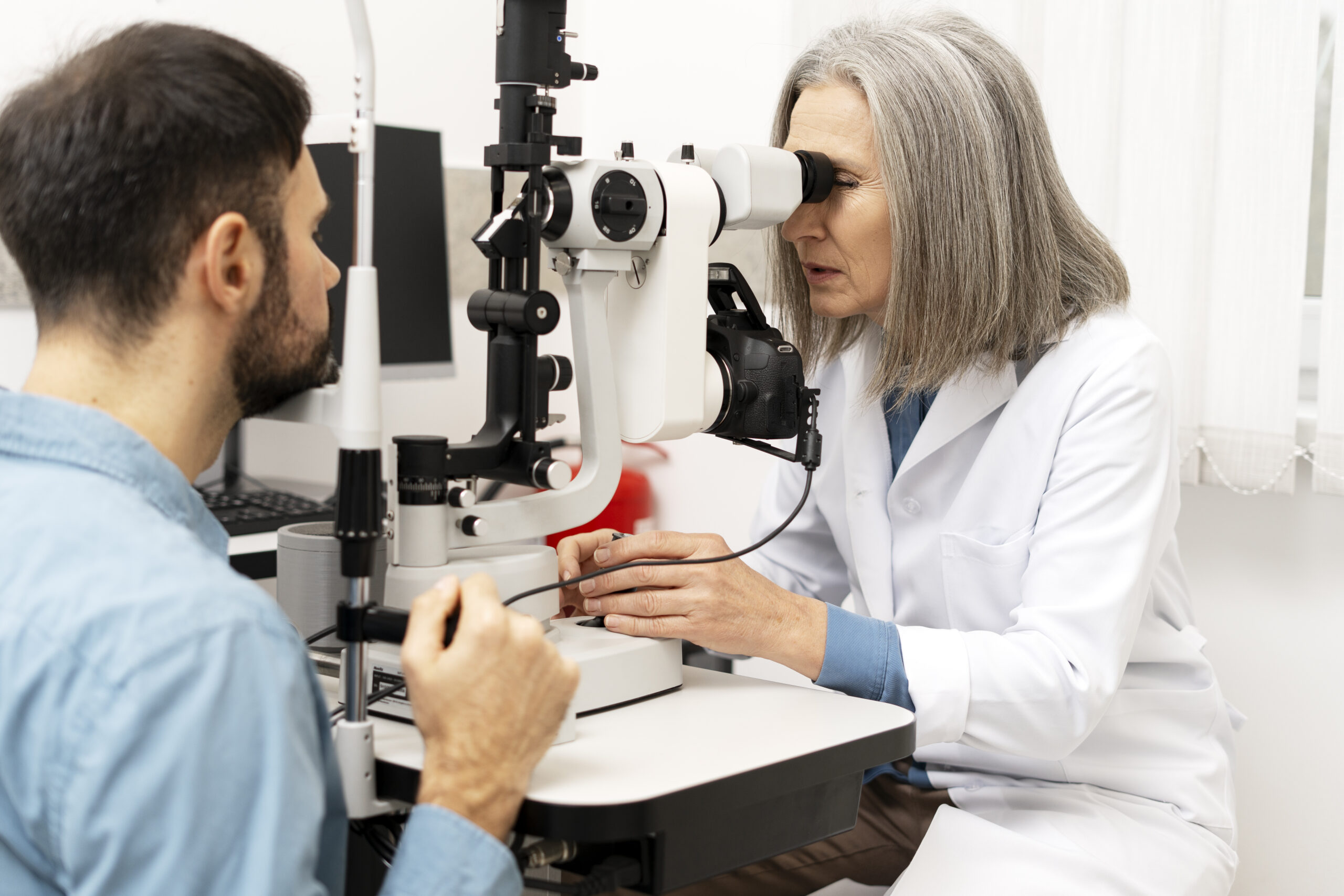 Optometrist examining a patient's eyes with a slit lamp.
